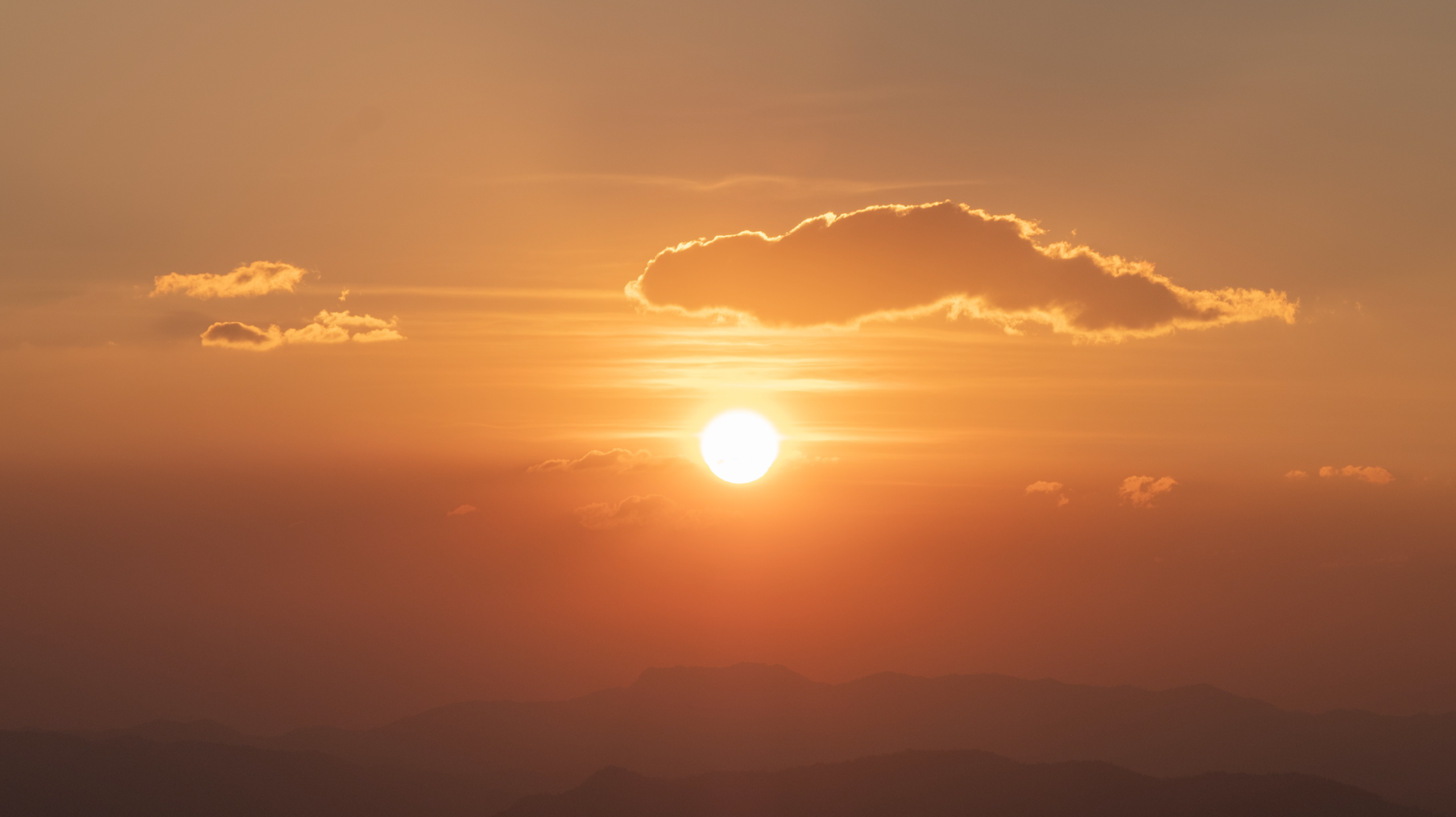 Screenshot of a stock footage item. The screenshot shows an orange sky with a few clouds and a bright sun mid-sunrise.