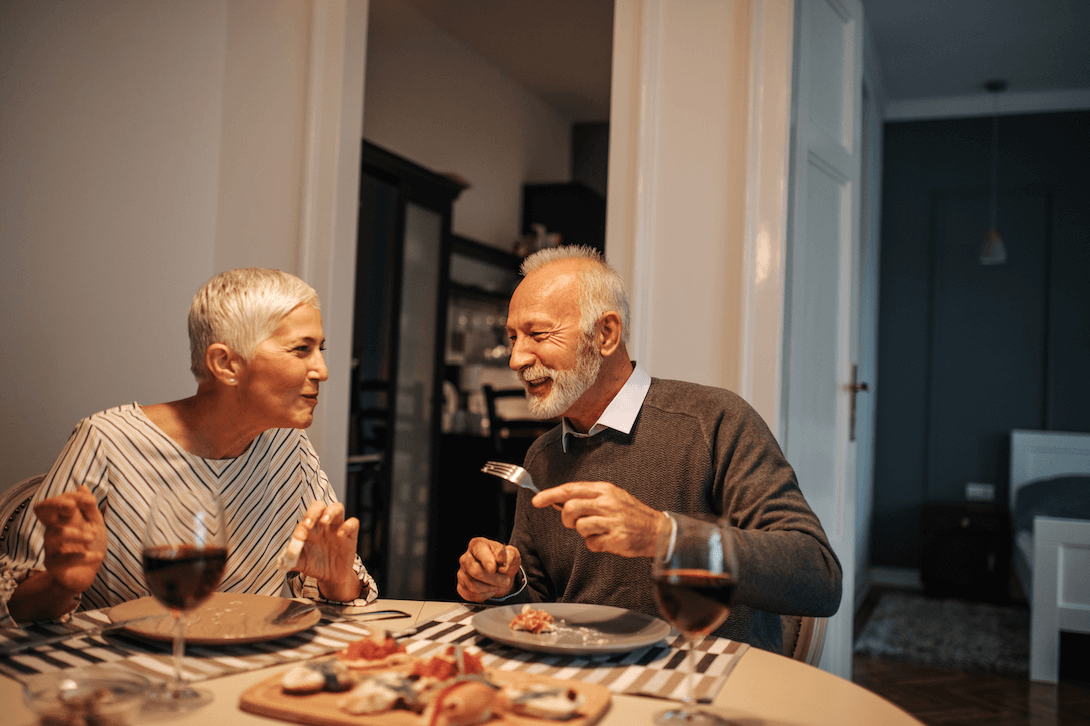 Older couple having romantic dinner in their home