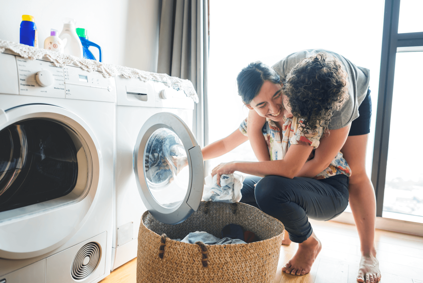 A photo from the 'authentic' collection, curated by our photo & video review teams. This photo depicts two women embracing in front of a washing machine.